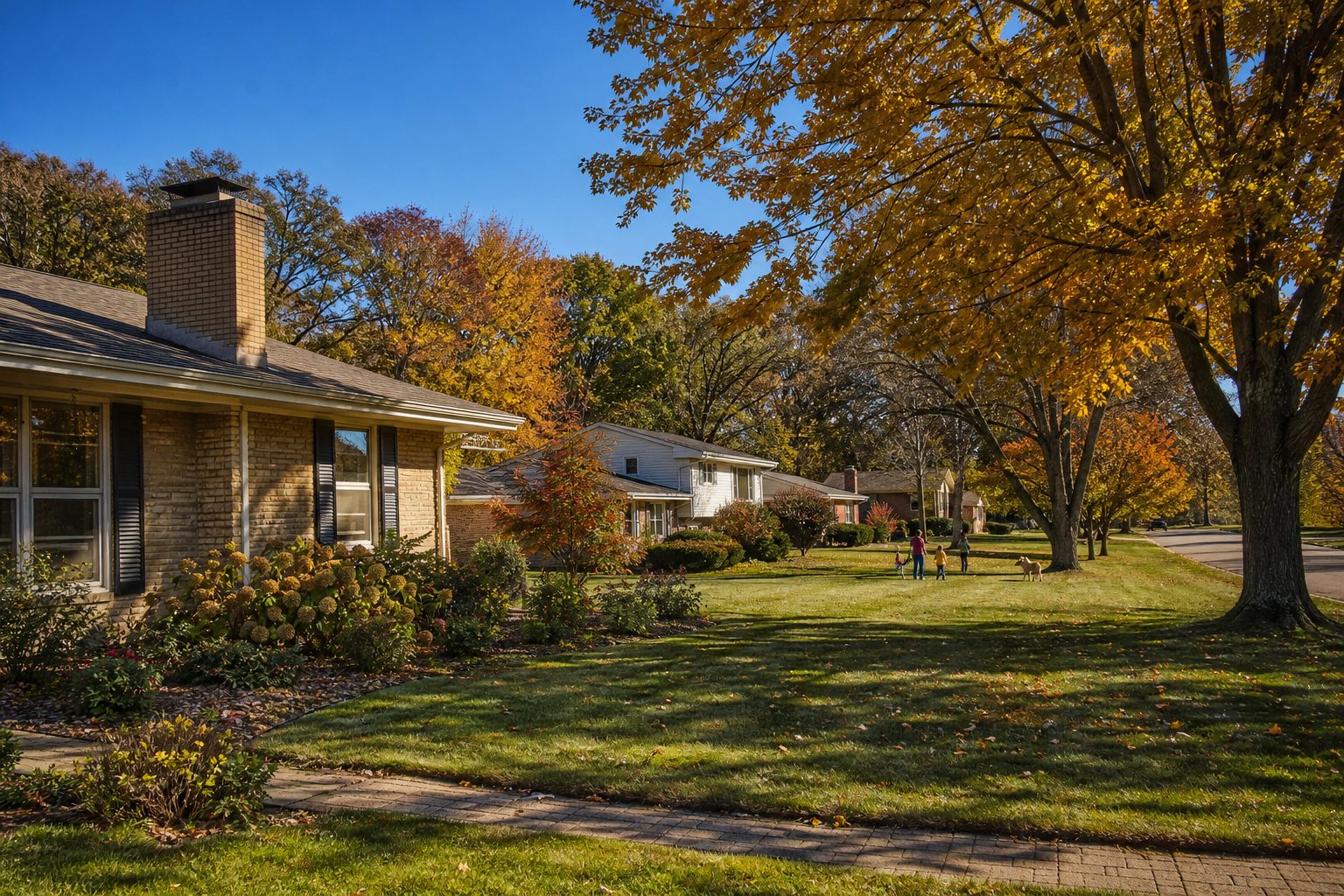 Tree-lined Heritage Heights street lined with 1960s ranch homes, mature autumn foliage, and distant park greenspace in Madison.